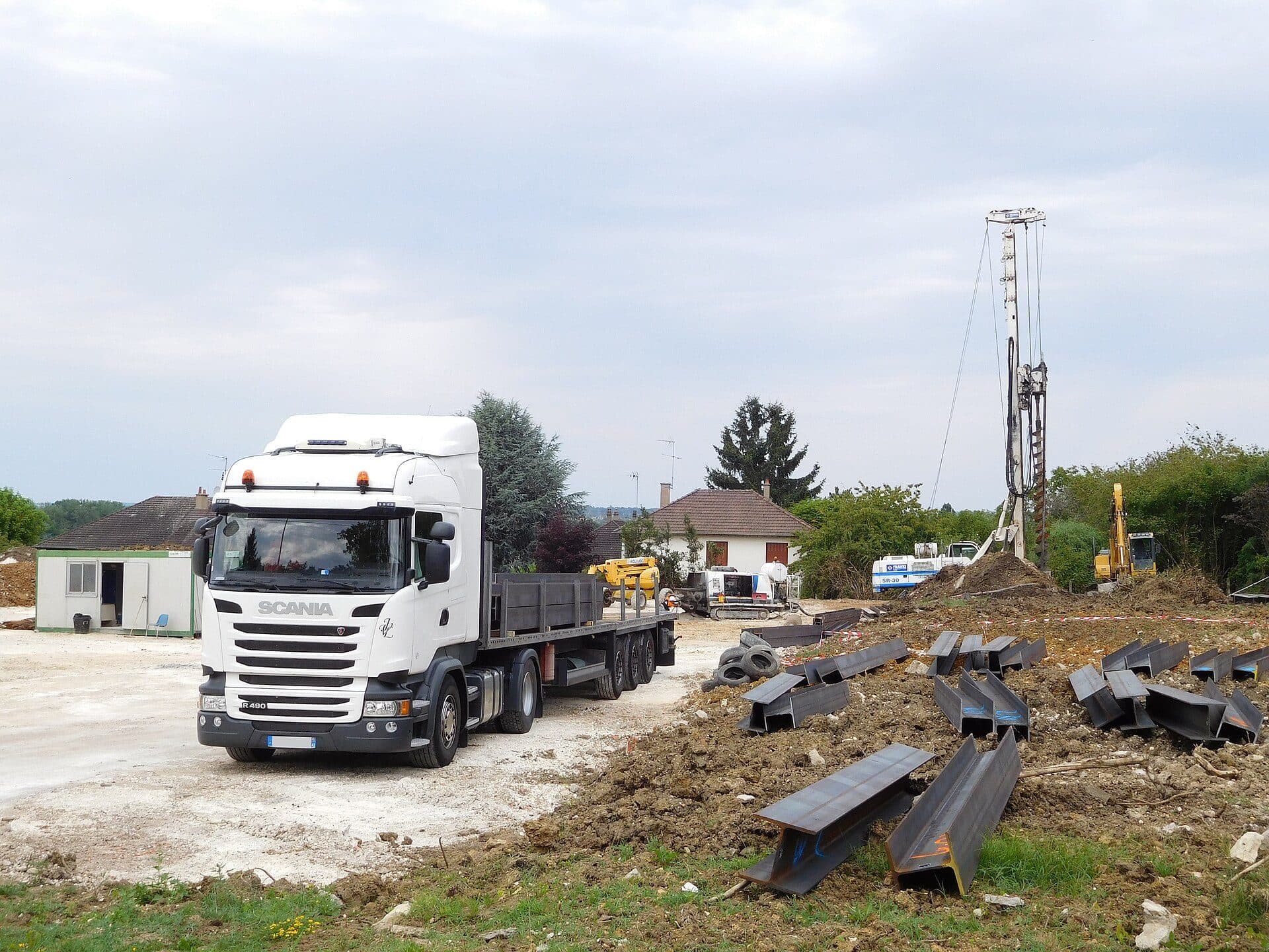 Flatbed trailer delivering structural steel to a construction site
