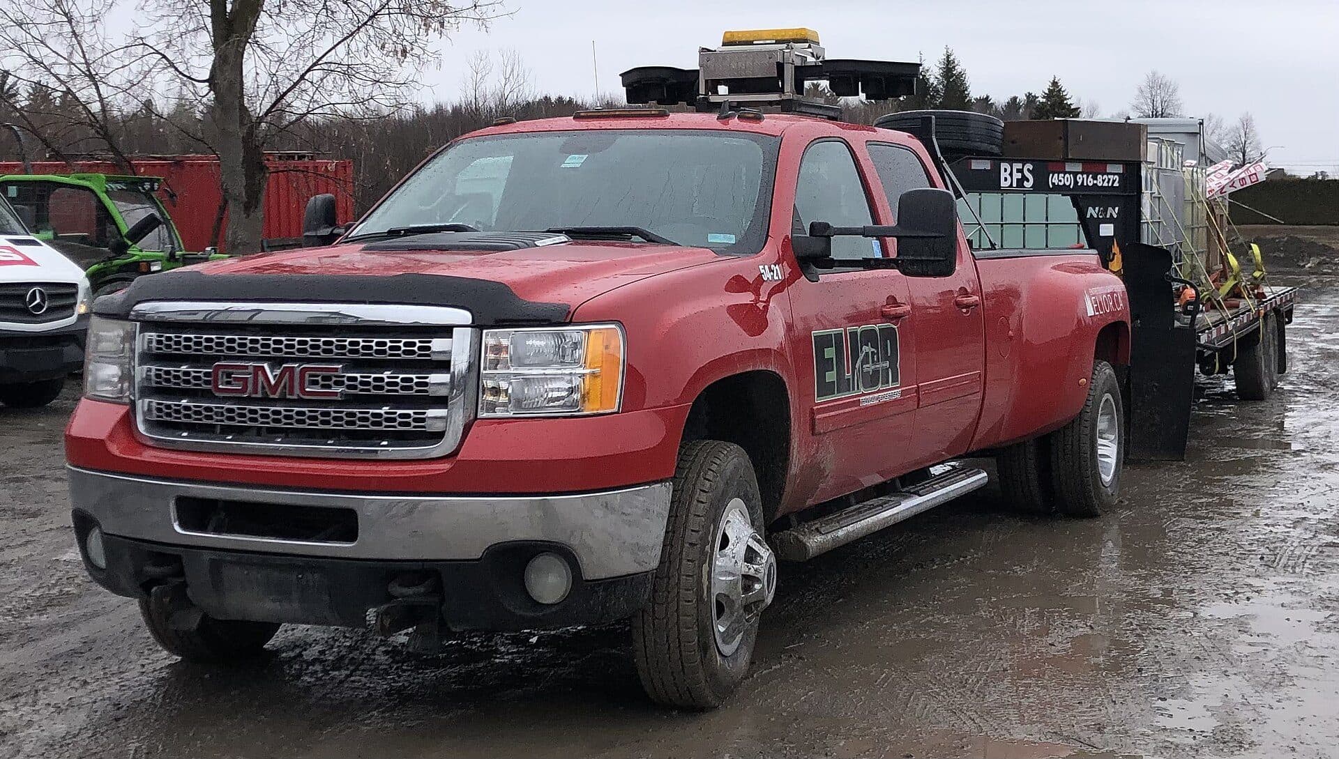 Red GMC Sierra dually hitched to a flatbed hotshot trailer