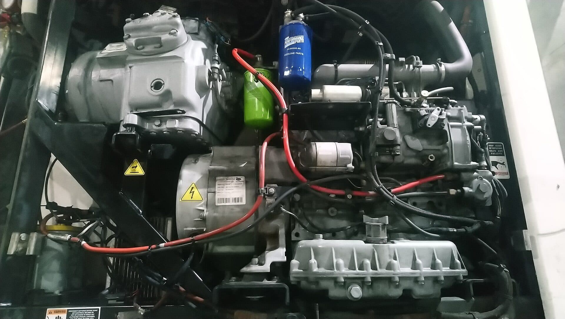 Diesel engine and compressor inside a trailer refrigeration unit with the cover open